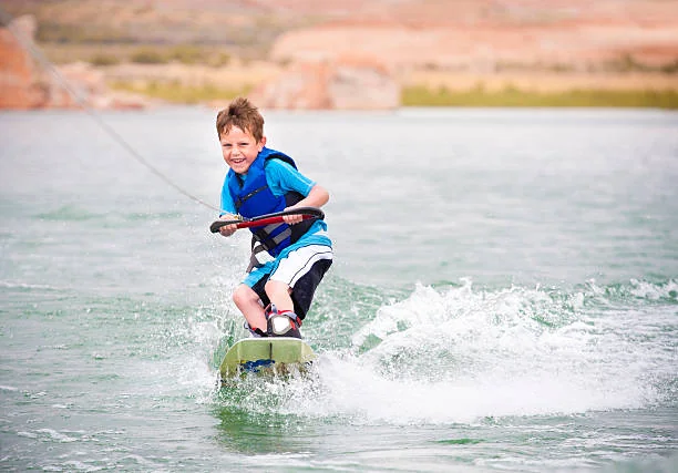 Un niño aprendiendo wakeboard